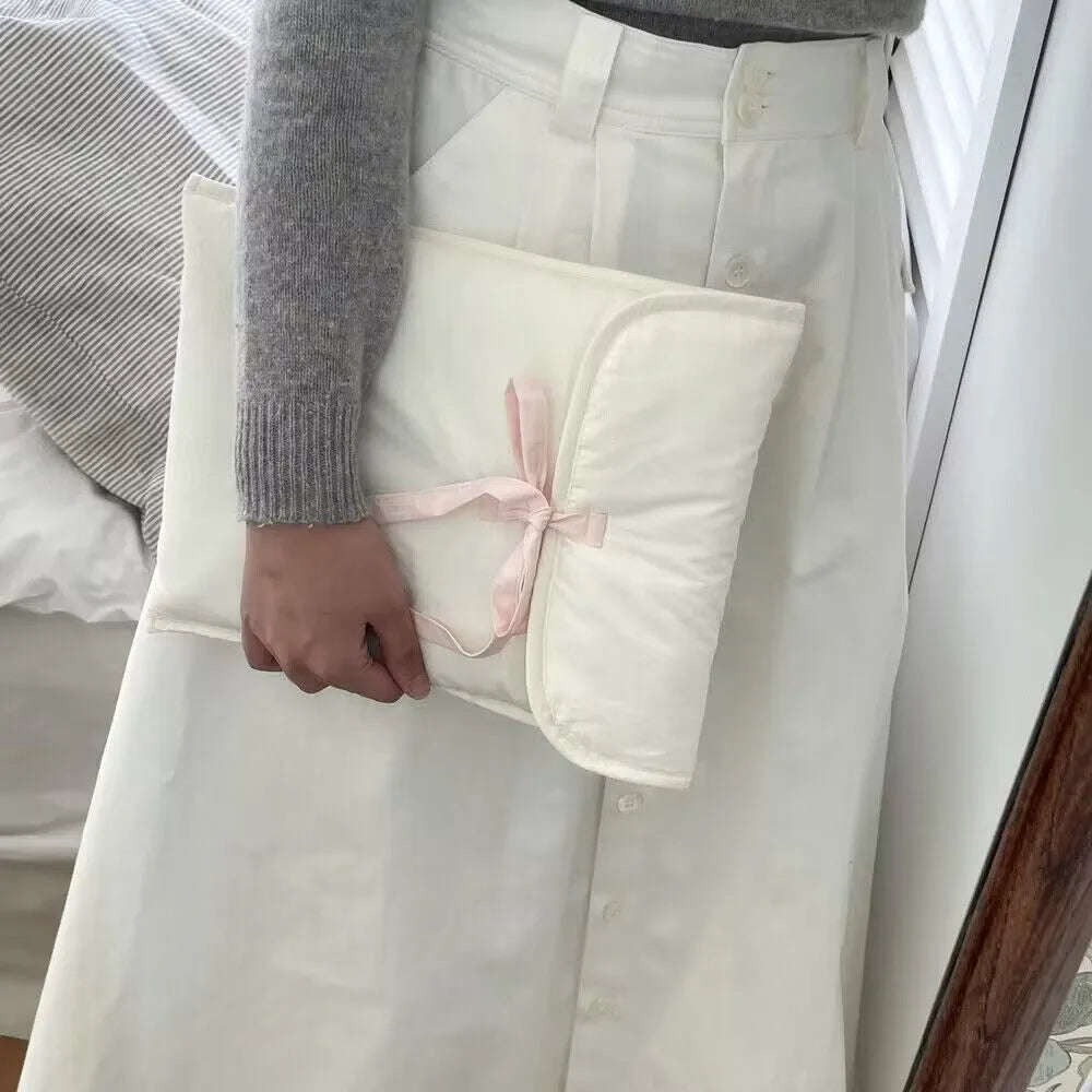 Black and white quilted women's laptop bag with striped pattern and ballet bow detail.