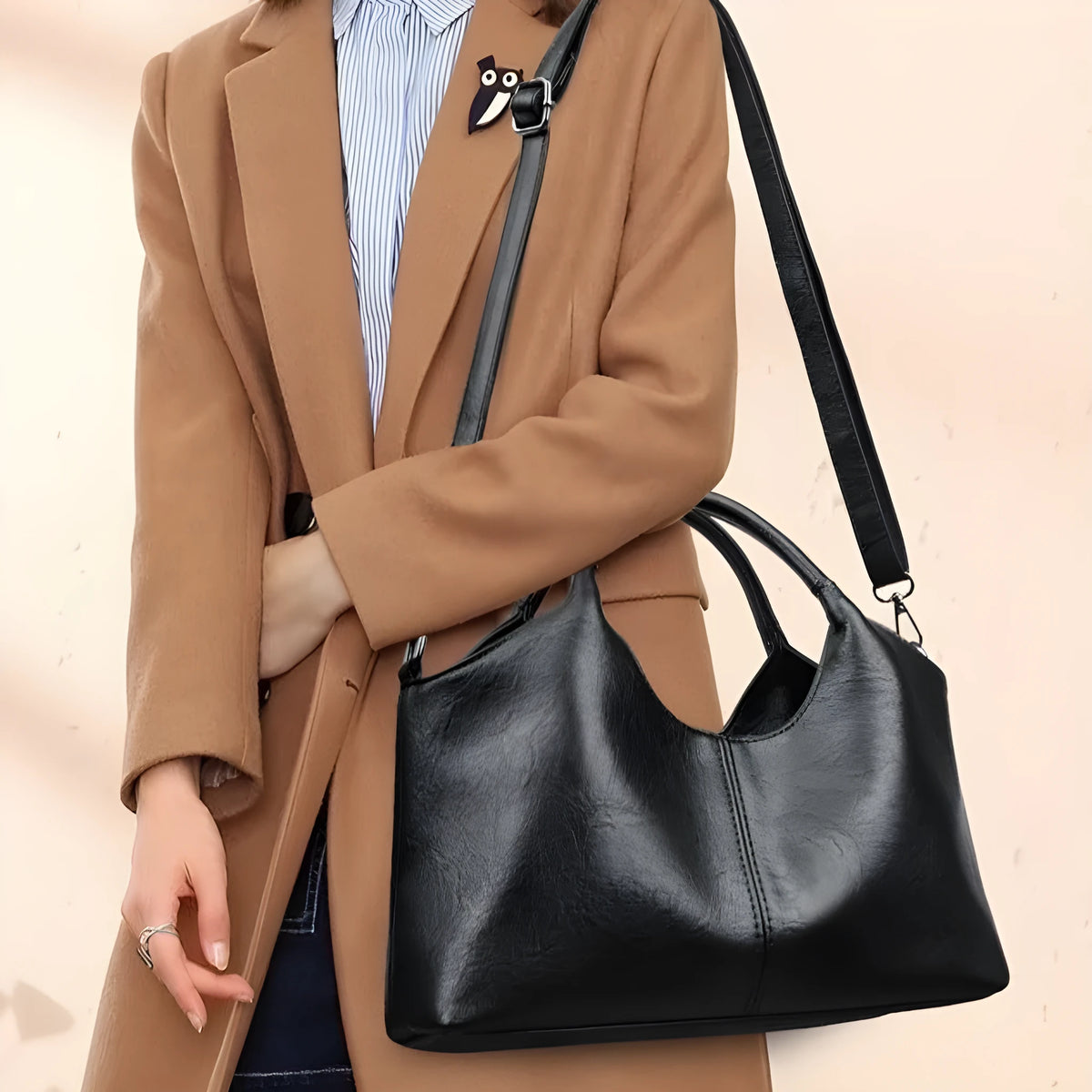 Genuine leather women's cross-body bag in black with adjustable shoulder strap showing interior polyester lining