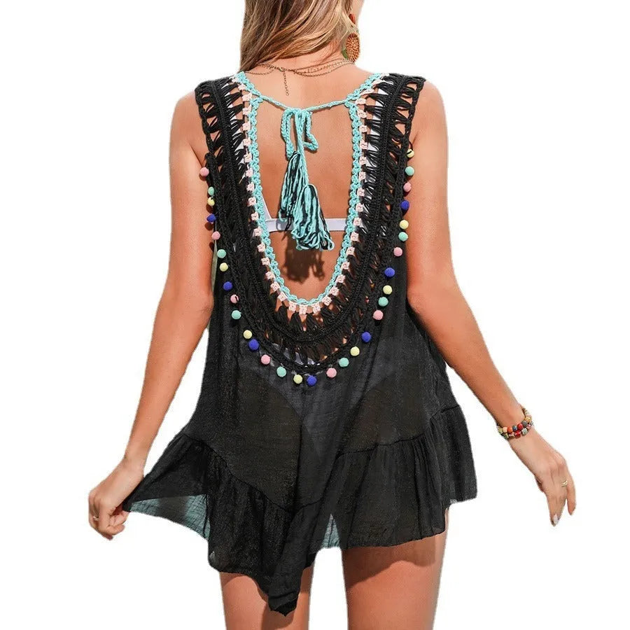 Black women's acrylic beach cover-up with crochet cut-out design and ruffle trim.