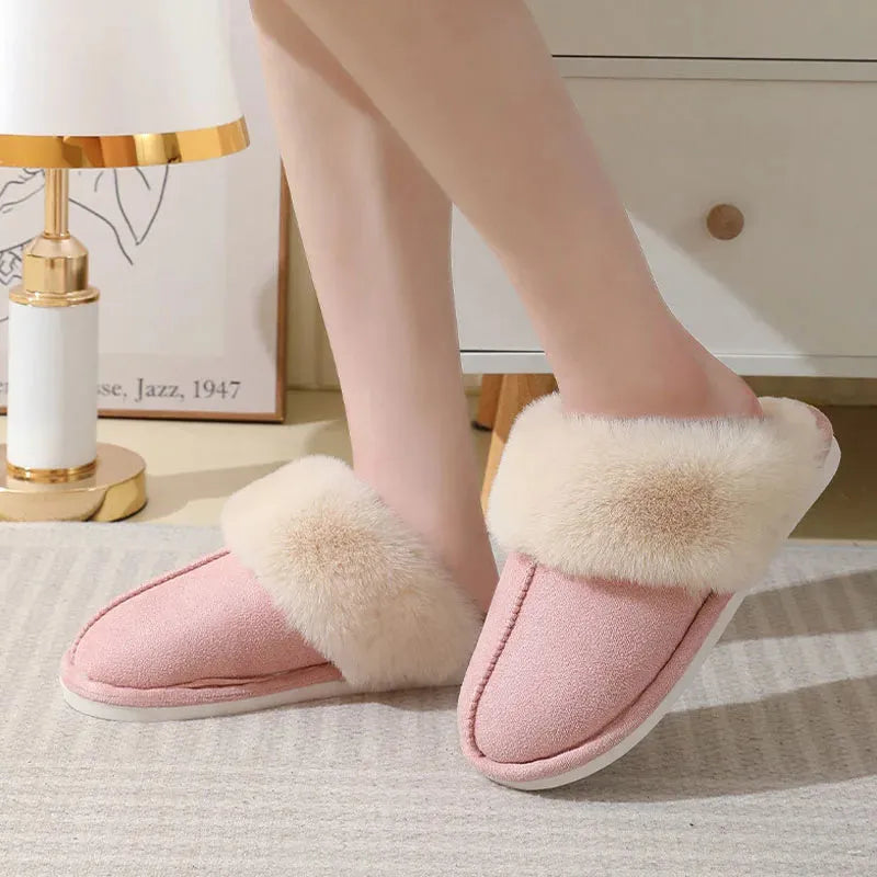 A pair of plush fur-lined indoor slippers with a round toe and a flat PVC sole.