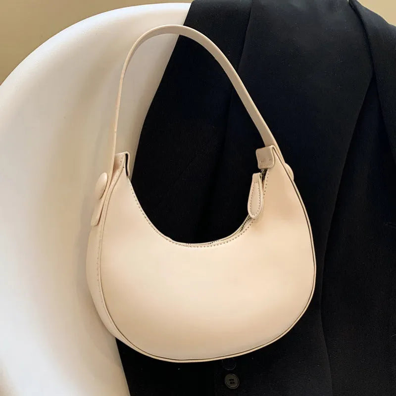 Women's retro-style dumpling-shaped PU leather shoulder bag in cream yellow, showing sandwich pocket.