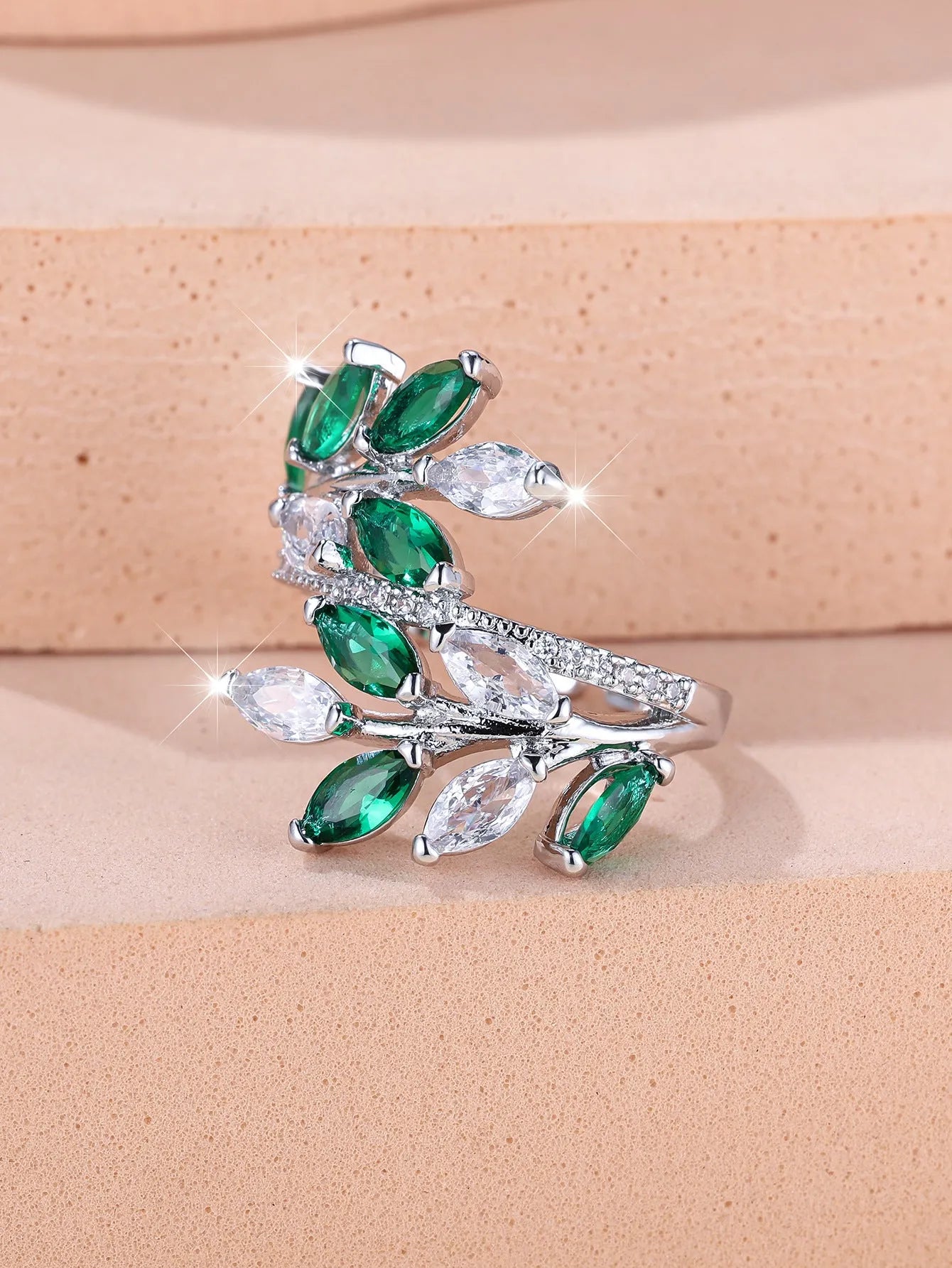 Adjustable opening copper leaf fashion ring with sparkling zirconia stones in a rose gold finish.