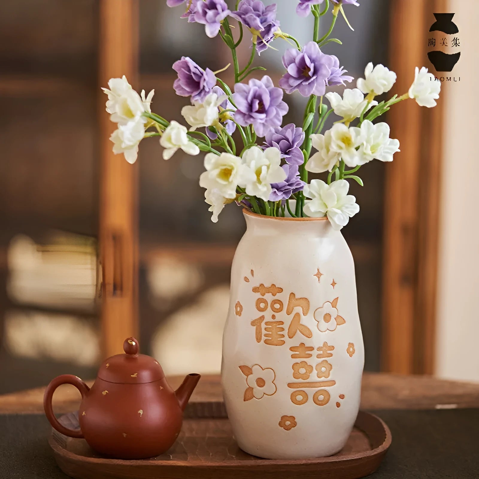 Chinese hand-painted ceramic vase with carved design on wooden desktop
