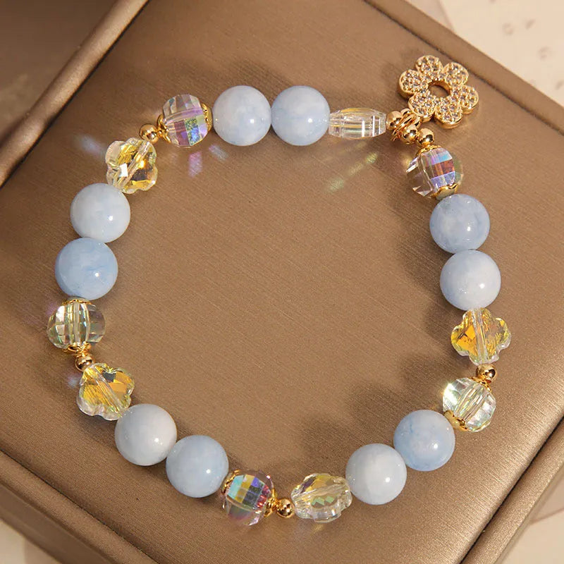Women's aquamarine crystal bracelet with four-leaf clover charm and pearl accents in light luxury design