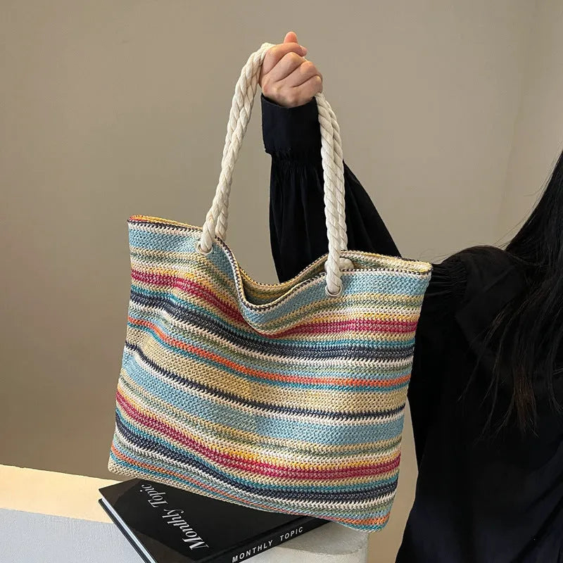 Blue straw-woven nylon shoulder bag with a single strap and large main compartment.