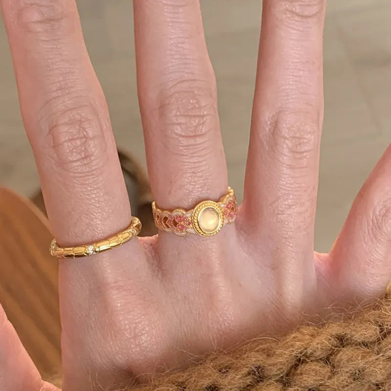 Open-mouth geometric women's ring with gold plating and pink crystal enamel detail on a white background.