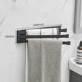 Nordic style black folding towel rack mounted on a white bathroom tile wall.