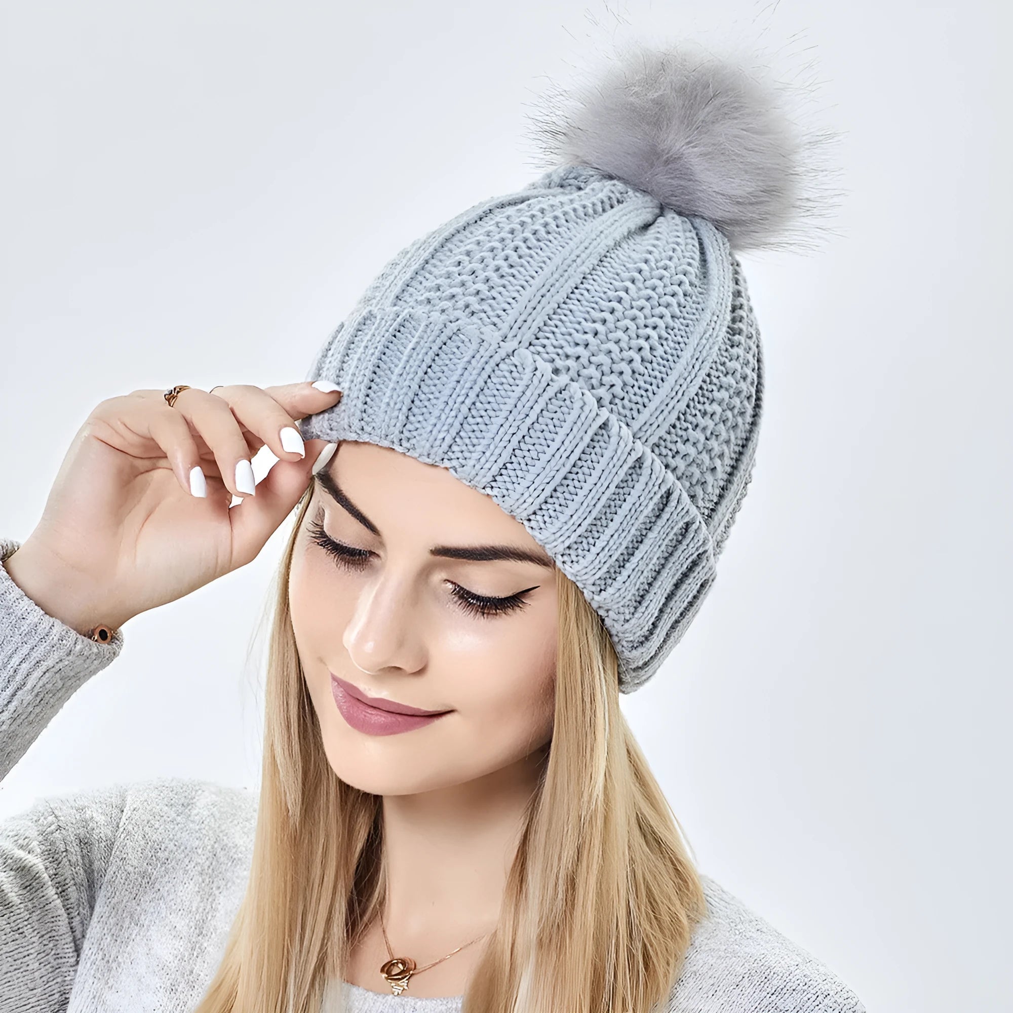Women's wool beanie hat with satin lining and a faux fur pom pom in a choice of eight colours.