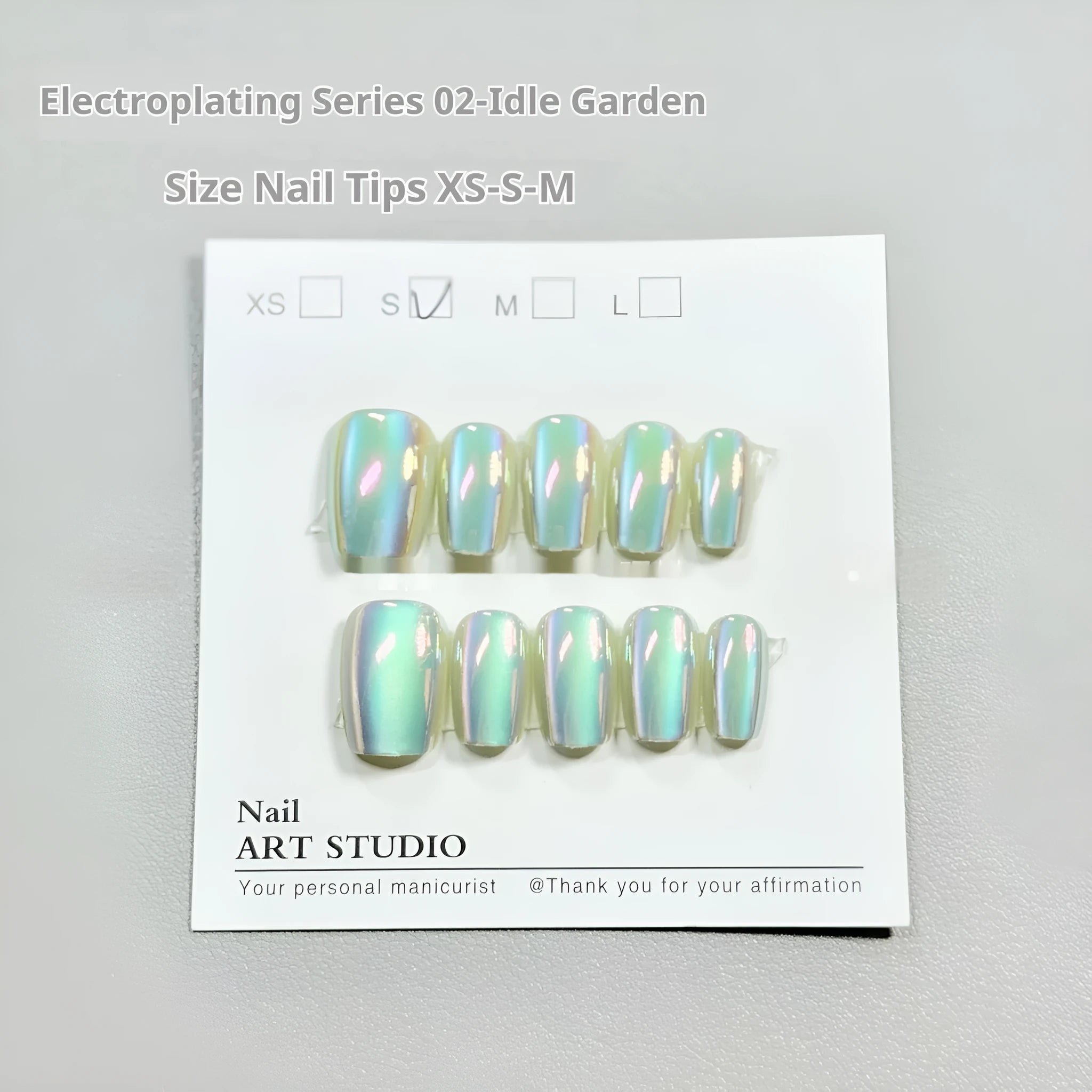 Cat's Eye electroplated false nails set with aurora glow in short ladder sizes on a hand.