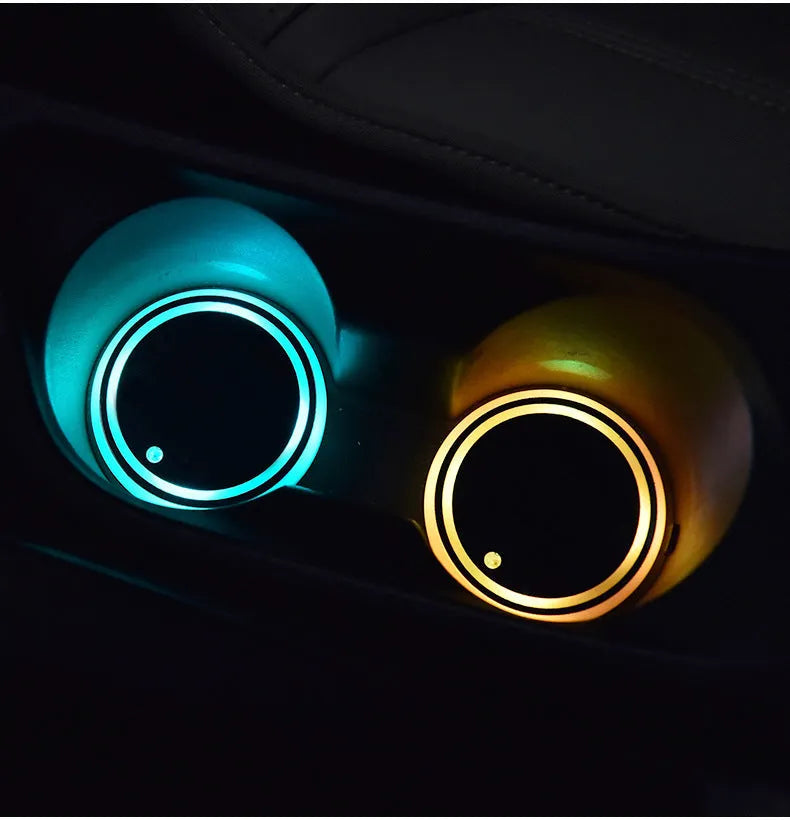 Colourful LED light-up coaster for car cup holder with USB cable on a car console.