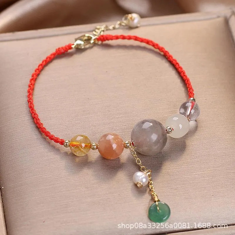 Close-up of a women's adjustable bracelet with crystal and sequin details on a hand-woven peace buckle clasp.
