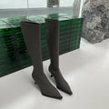 Black women's pointed toe below-the-knee boots with a stiletto heel and a back zipper closure on the side.