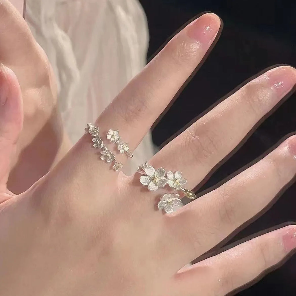 Three-dimensional jasmine flower ring with adjustable open mouth design in zinc alloy.