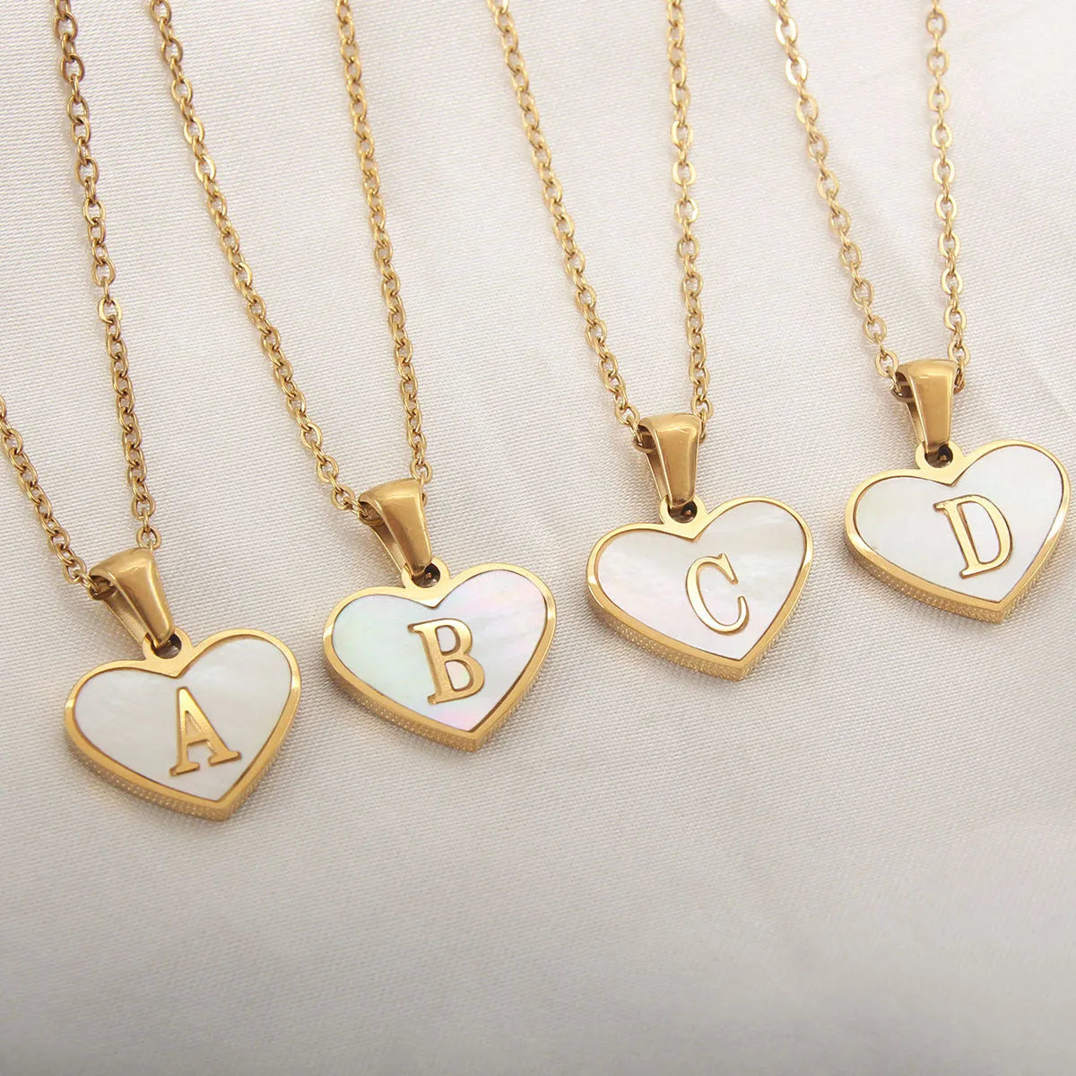 Gold-plated heart necklace with white shell accent and personalised letter pendant on stainless steel chain