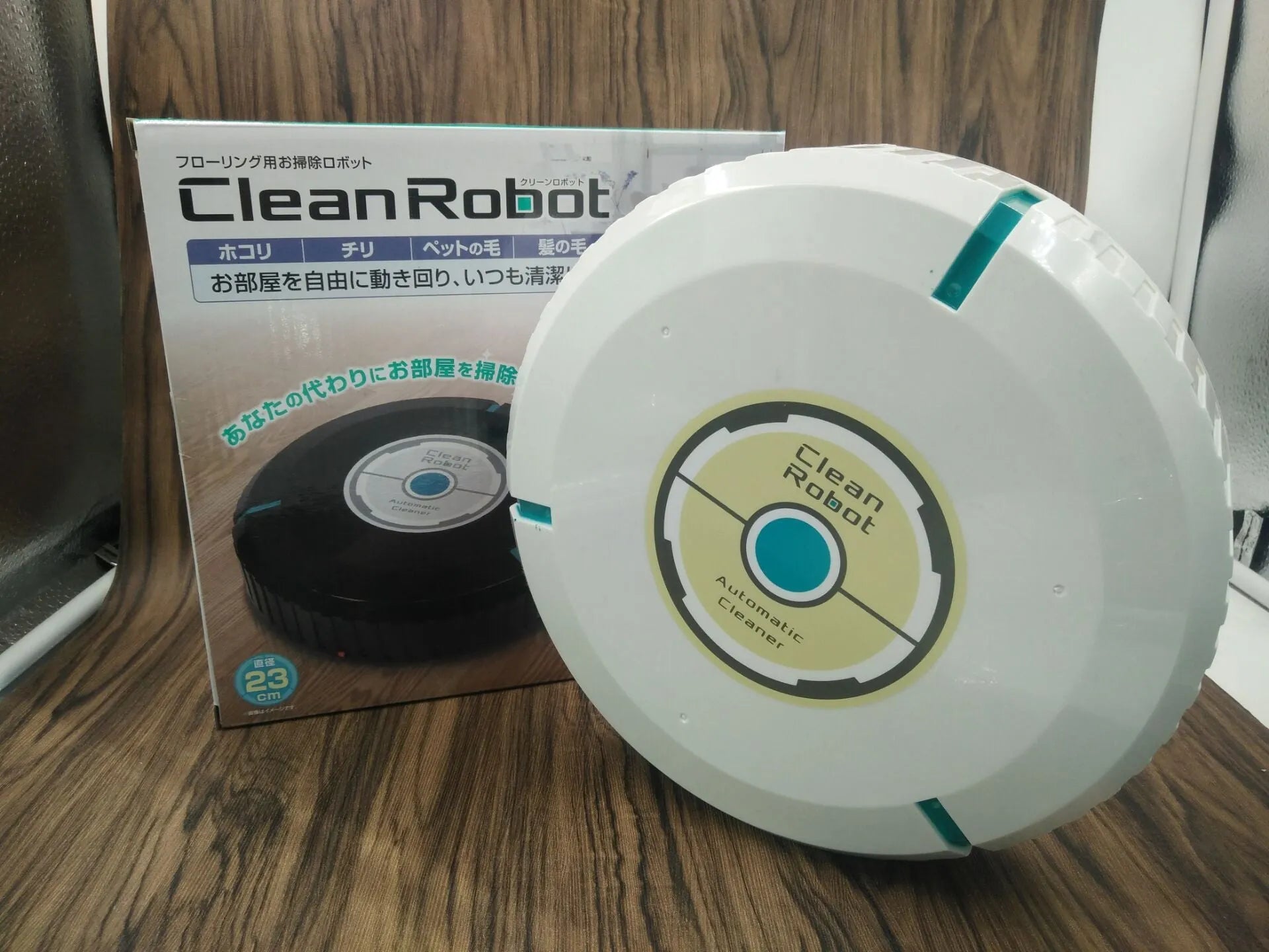 Black and white AC robot vacuum cleaner on wooden floor