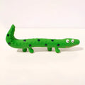 Green cartoon lizard-shaped latex dog chew toy with squeaker on a white background.