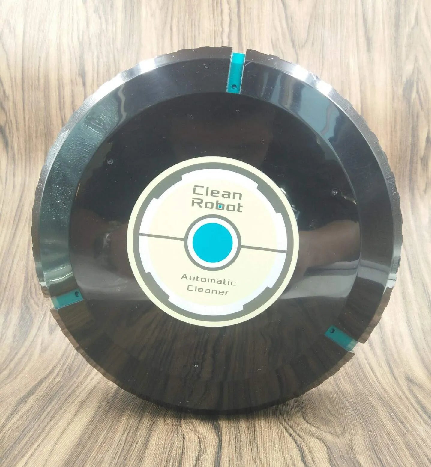 Black and white AC robot vacuum cleaner on wooden floor