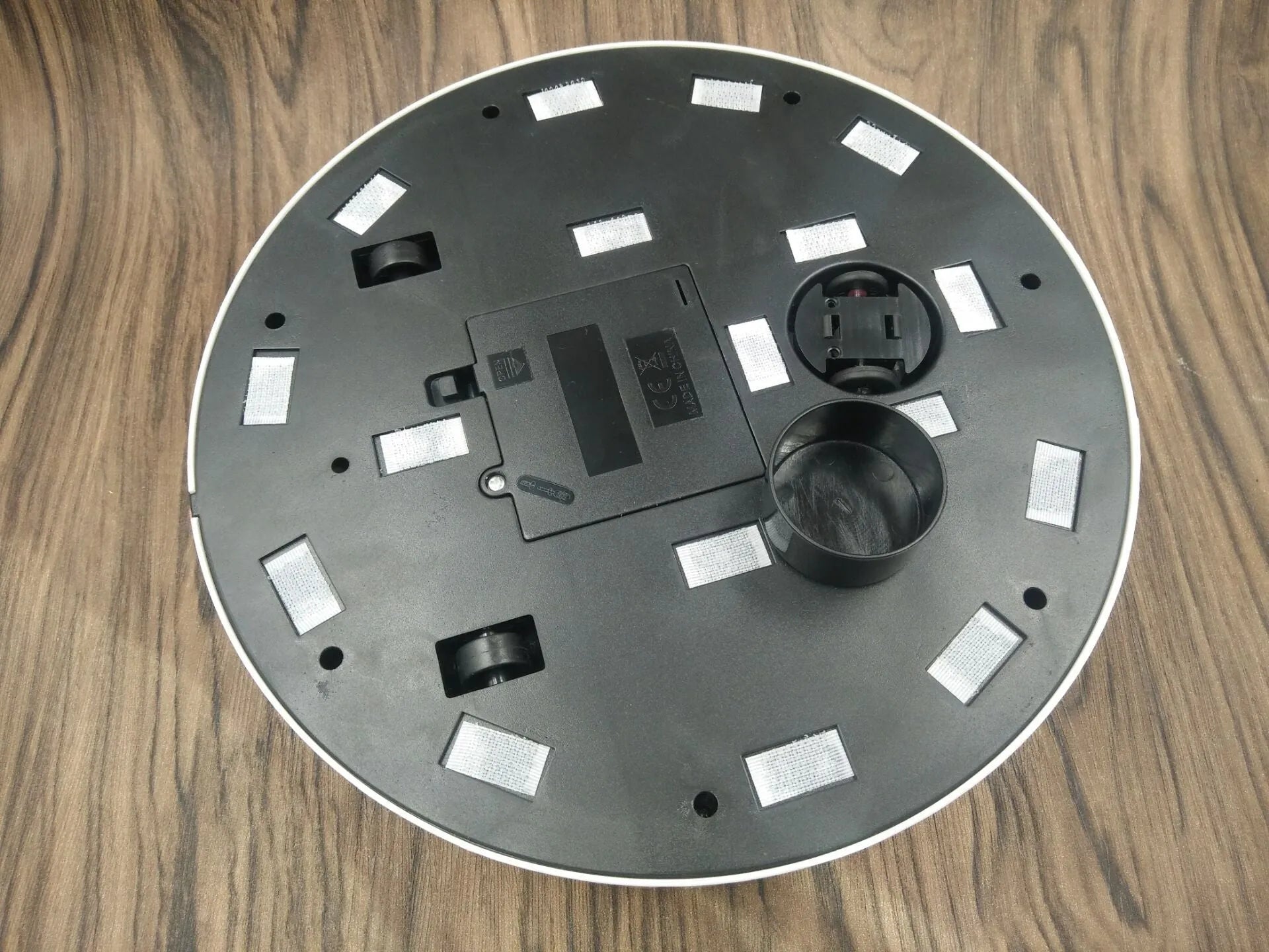 Black and white AC robot vacuum cleaner on wooden floor