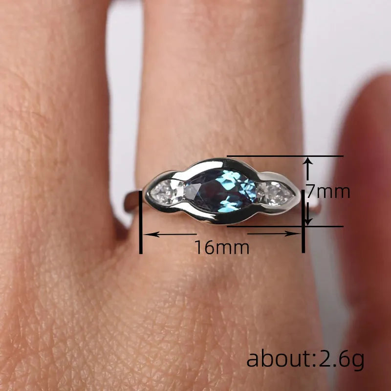 Geometric ellipse ring with inlaid zircon stones in white gold colour on female hand
