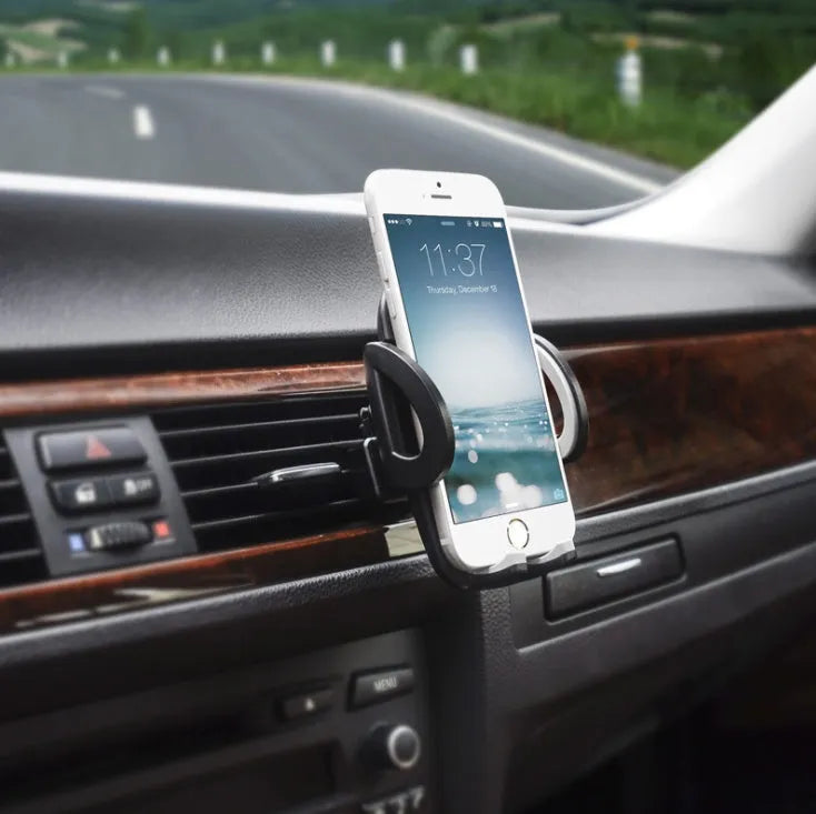 Black mobile phone holder clipped to car air conditioning vent with smartphone mounted