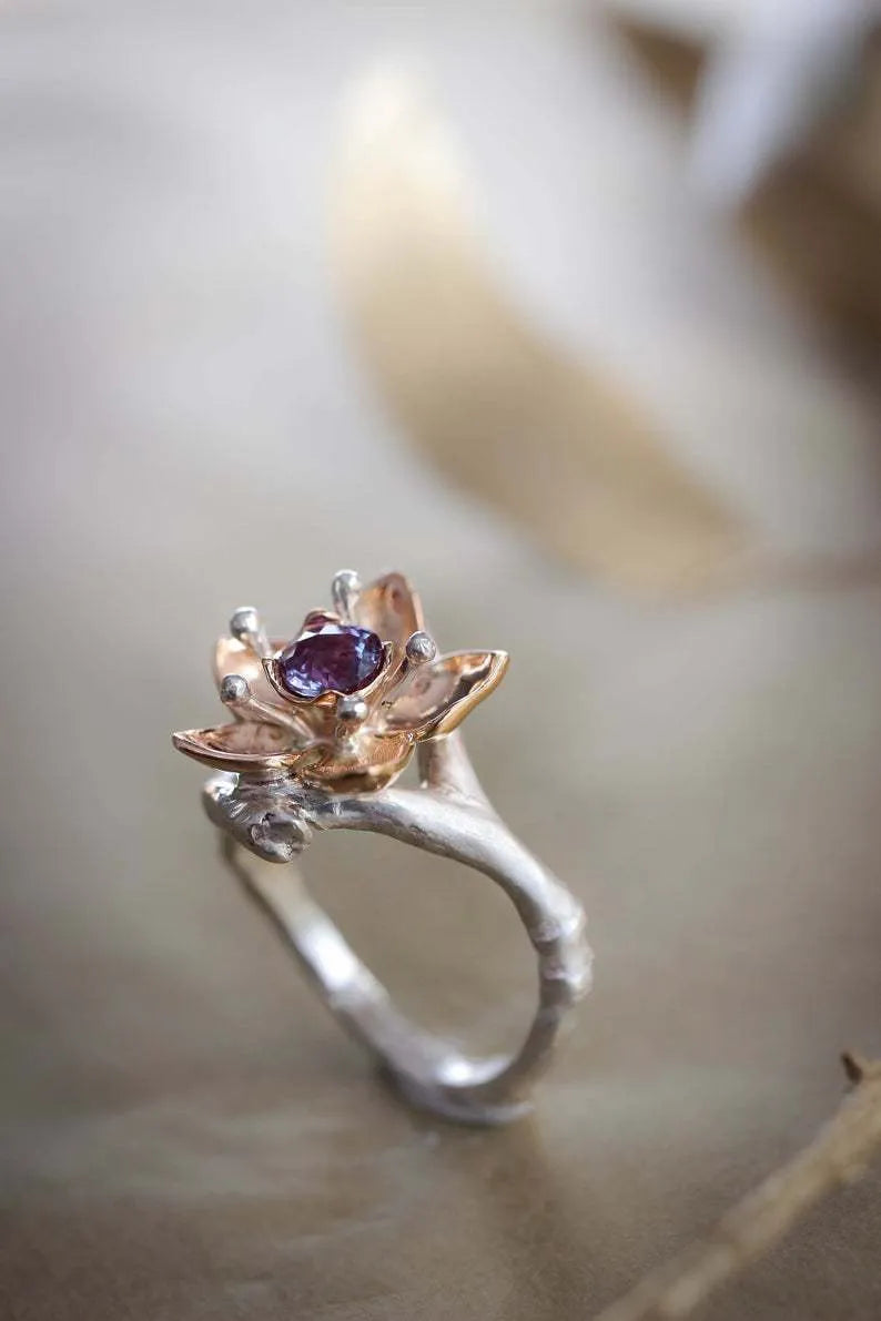 Silver two-tone women's floral ring with a simple geometric shape on a neutral background.