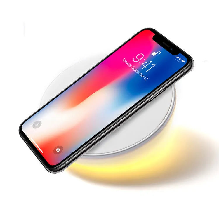 White wireless smartphone charger with digital clock display and three control buttons on the front.