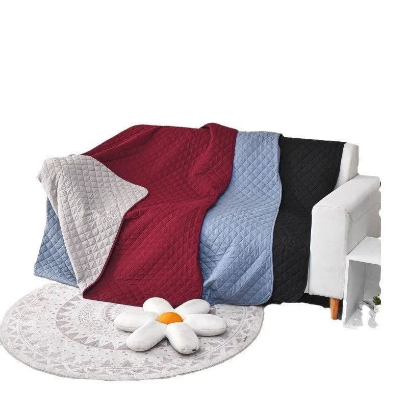 Reversible waterproof dog blanket on sofa showing two colour options with multiple size measurements