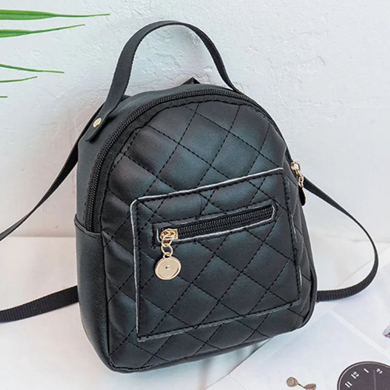 Hard-sided square pink backpack with embroidered detail, shown with soft carry handle and straps.