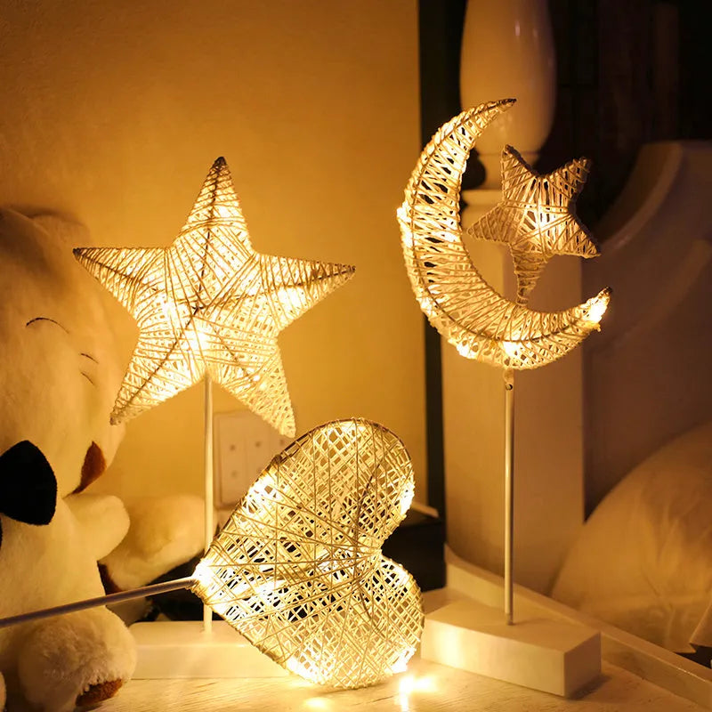 Rattan and copper wire LED table lamp in a star shape on a bedside table.