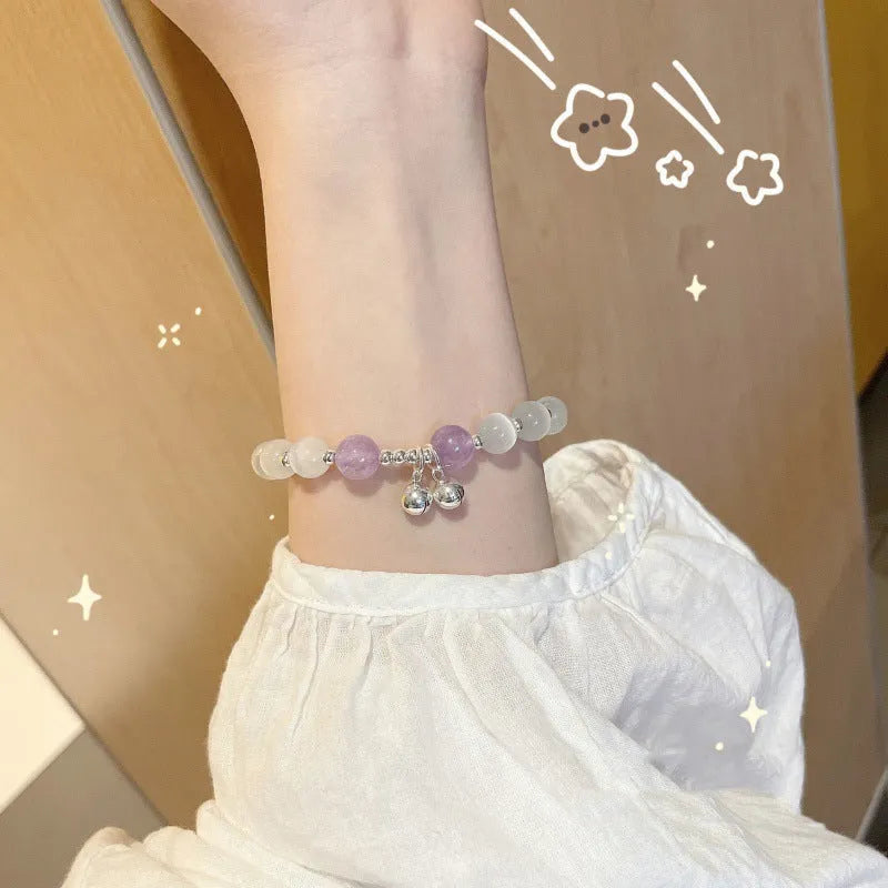 A Chinese style glass bracelet with bamboo leaf and bead designs on a wrist.