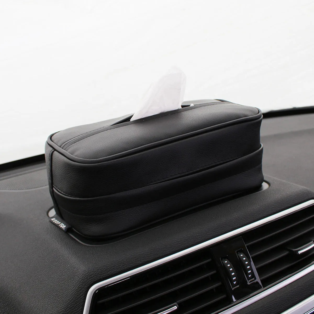 Black PU leather hanging storage box for car console organisation, shown with paper bag filler.