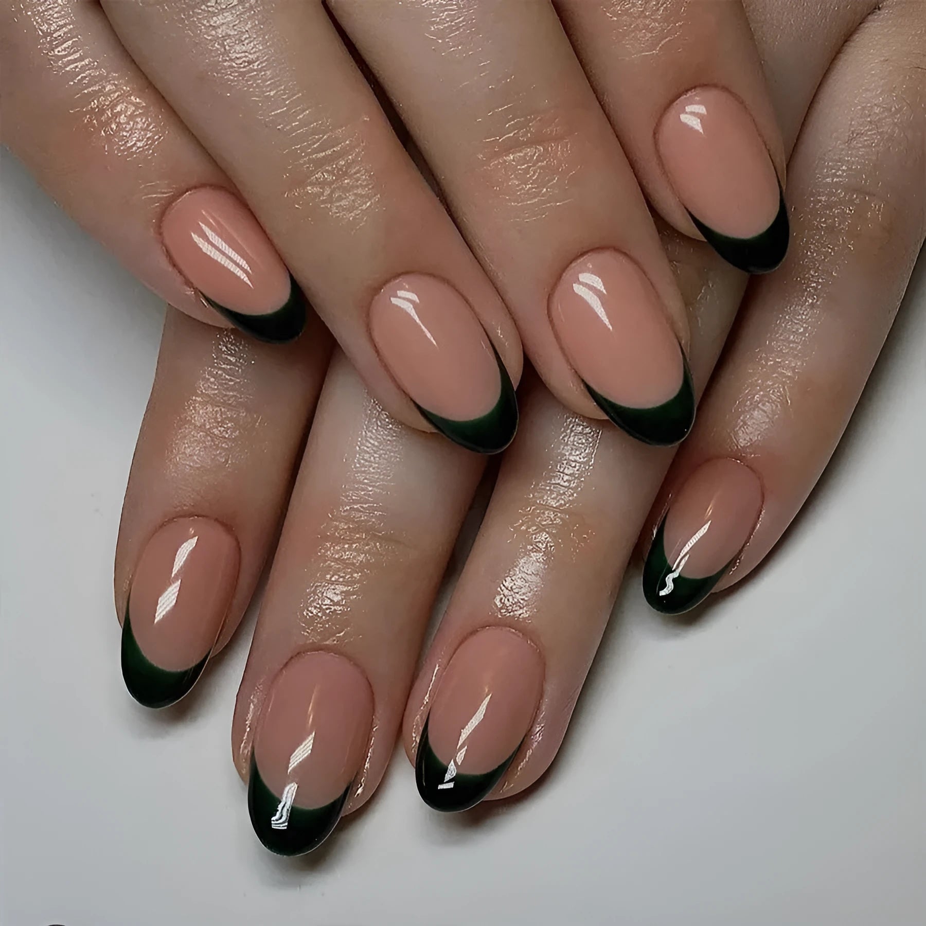 Set of 24 short almond coffin shaped press-on nails with black French tips on a white base.