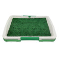 Green artificial turf dog toilet with removable plastic collection tray for indoor potty training.