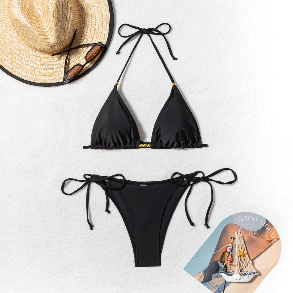 Black women's bikini swimsuit with split front and silver metal bead decoration.