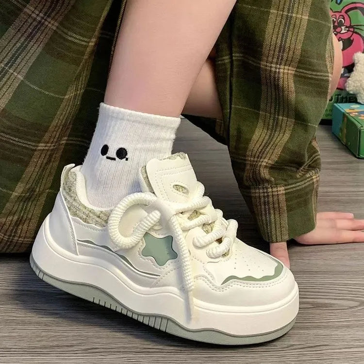 Women's green platform sneakers with round toe and lace-up design on a white background.