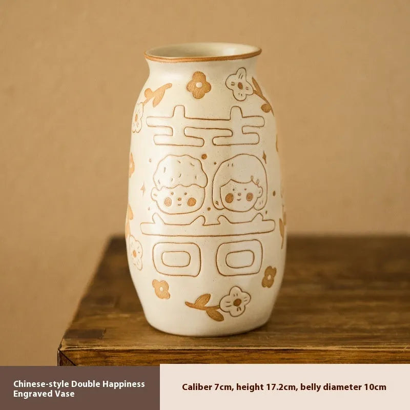 Chinese hand-painted ceramic vase with carved design on wooden desktop