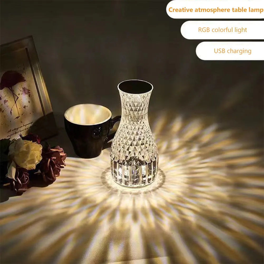 White crystal vase-shaped table lamp with remote control on a wooden surface.