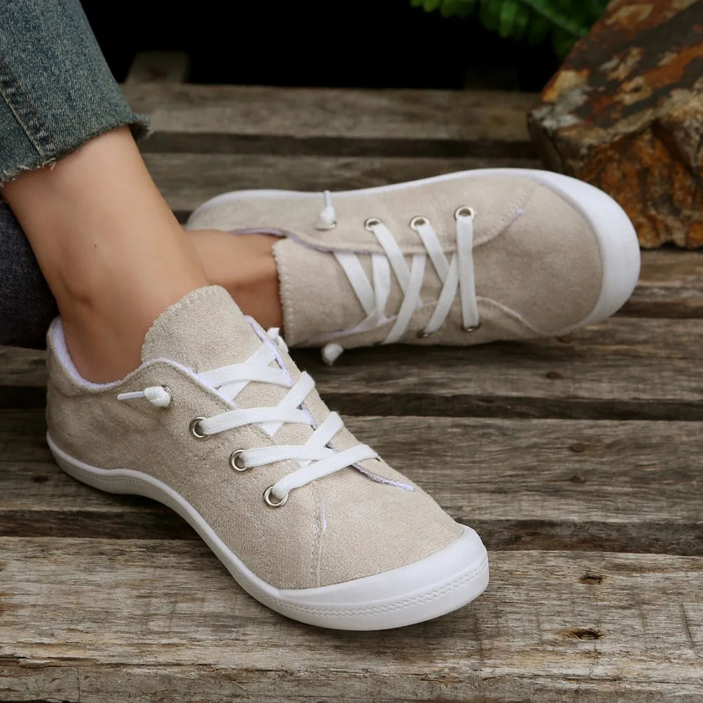Women's low-top creamy white fabric sneakers with a wear-resistant rubber sole on a neutral background.