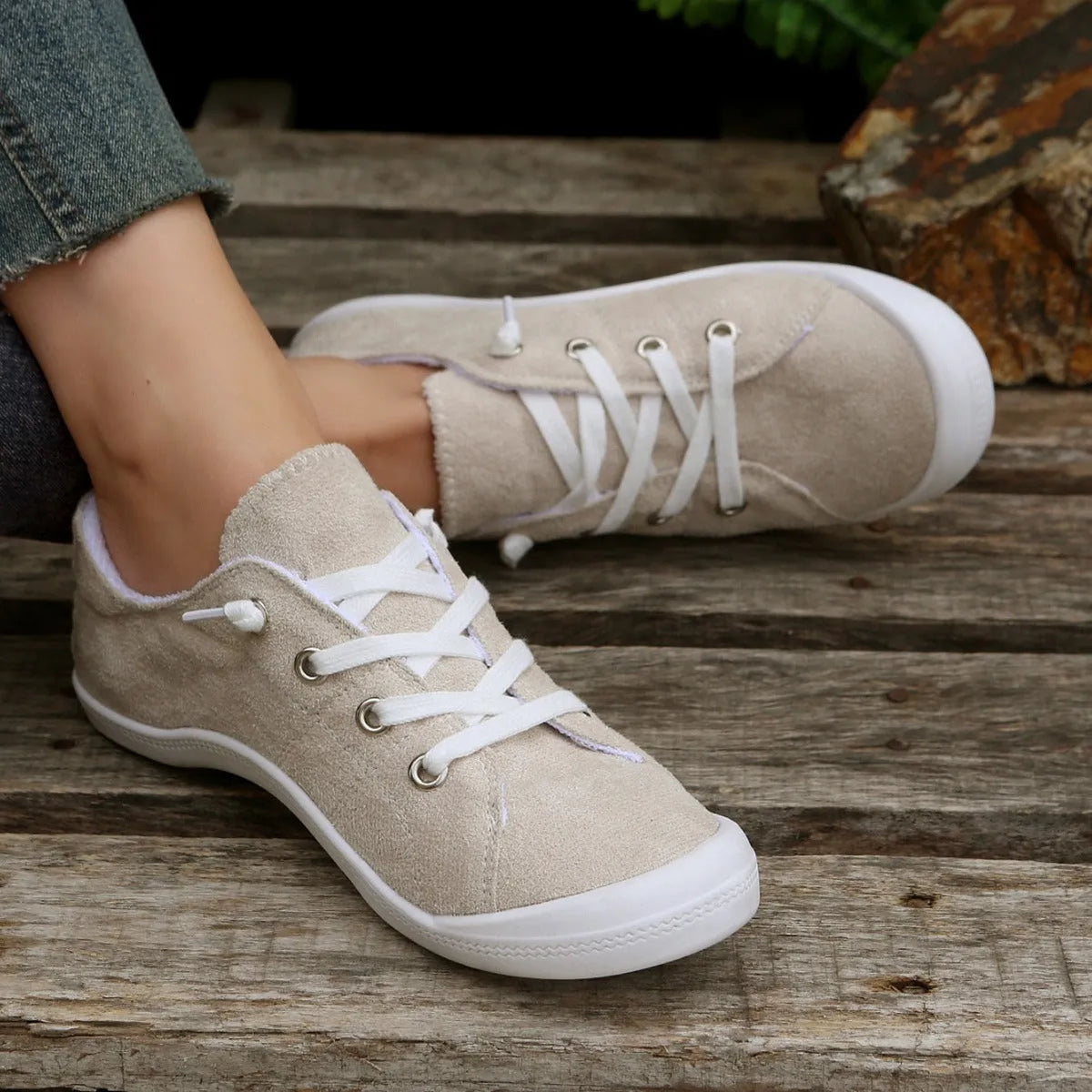 Women's low-top creamy white fabric sneakers with a wear-resistant rubber sole on a neutral background.