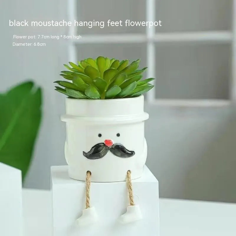 Ceramic cartoon-style succulent flowerpot with hanging foot design on desktop