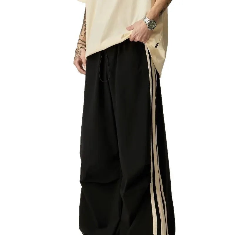 Men's black climbing trousers with high waist and wide straight leg design on hanger