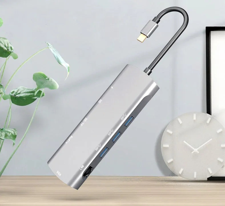 Grey aluminium USB-C docking station with HDMI, VGA, USB ports, and a short connecting cable