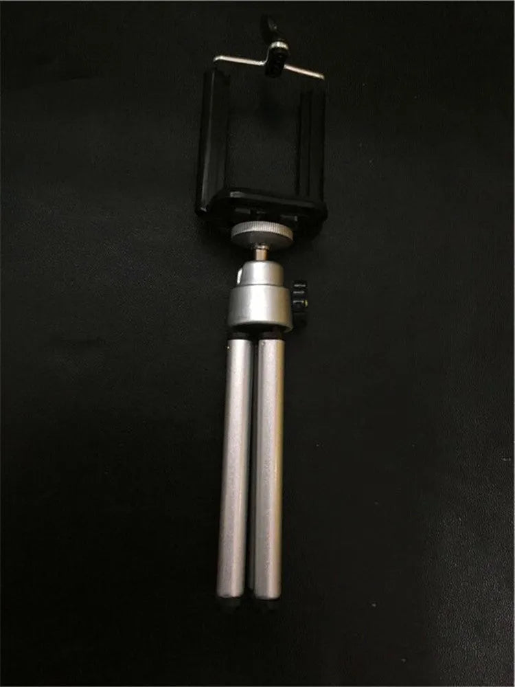 Black and silver desktop phone holder with two-section adjustable bracket on a desk