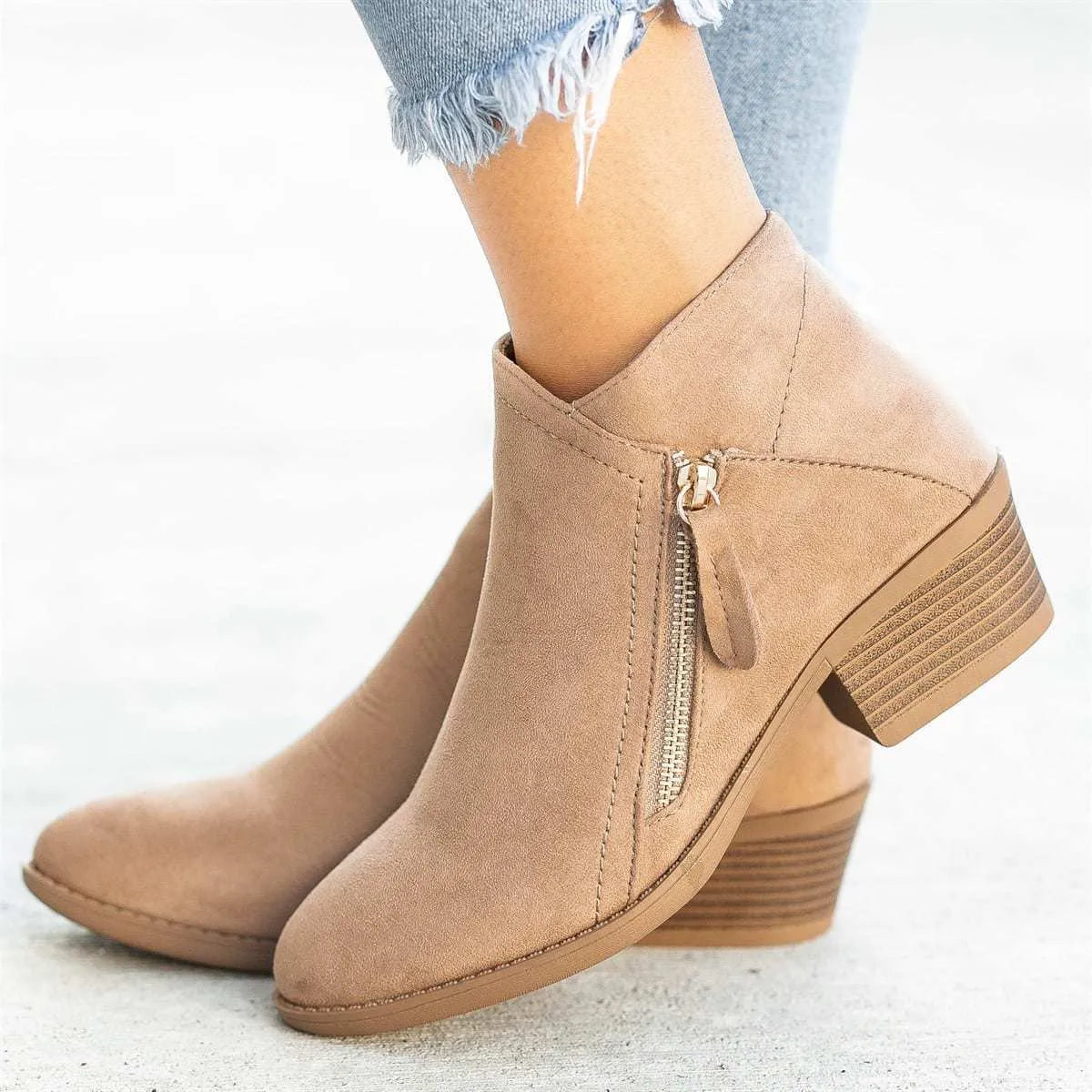 Women's blue suede ankle boots with a side zip and chunky heel, shown on a foot.