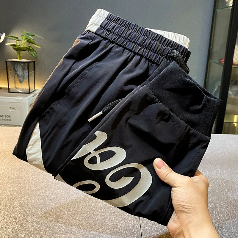 Men's solid black cropped trousers with banded ankle cuffs made from thin ice silk cotton fabric.