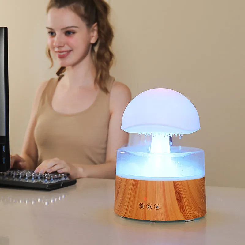White Rain Cloud Humidifier showing raindrop effect, colour-changing light, and remote control on a table.