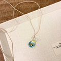 Women's joker design pendant necklace with coloured glaze charm on a cotton and linen clavicle chain.
