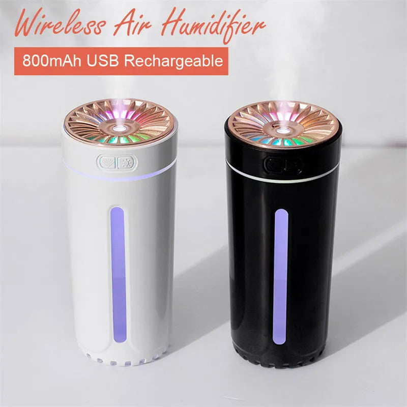 Black portable USB rechargeable car humidifier with colourful lights on a desk next to a cup
