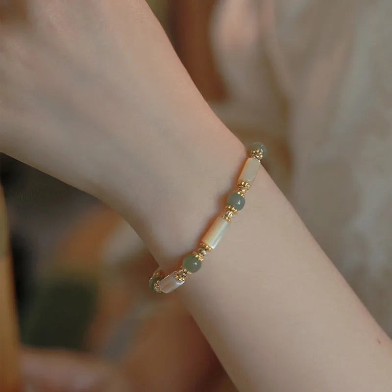 Natural Hetian jade white lip shell bracelet with geometric round beads on woman's wrist