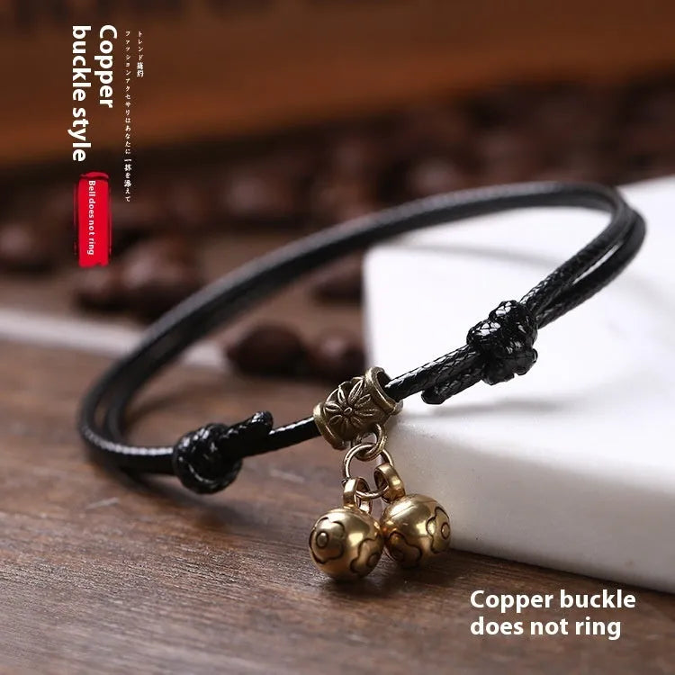 Small dog collar made of nylon rope with a brass bell, shown in black colour.